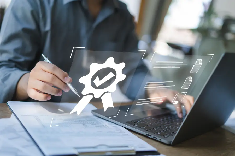 Person signing documents at a laptop