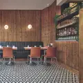 Restaurant with timber-clad walls, booth seating and patterned floor tiles
