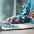 Person ticking off a checklist on a laptop