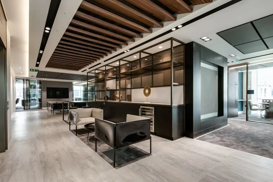 Office lounge with leather armchairs, a timber slatted ceiling and shelving