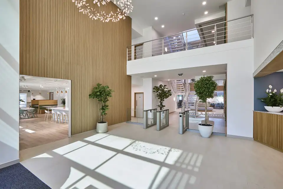 Bright office reception with speed gates, planting and a mezzanine