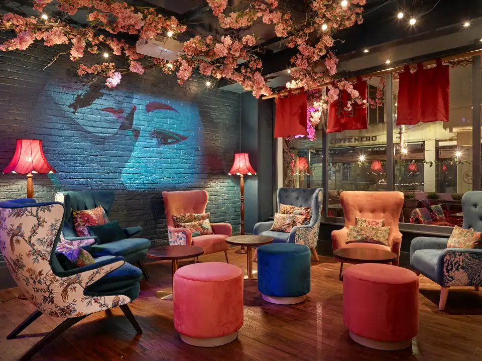 Restaurant lounge with a cherry blossom ceiling, patterned armchairs and pouffes