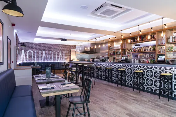 Aquavitae cocktail bar with a patterned tiled bar front and booth seating