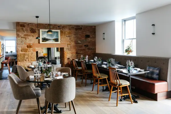 Pentonbridge Inn dining room with an exposed stone wall