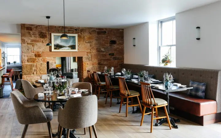 Pentonbridge Inn dining room with an exposed stone wall
