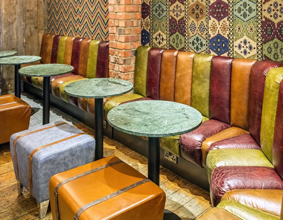 Multicoloured leather bench seating and low stools at A Wanted Man