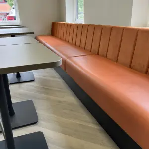 Amiosec break-out area with orange upholstered bench seating