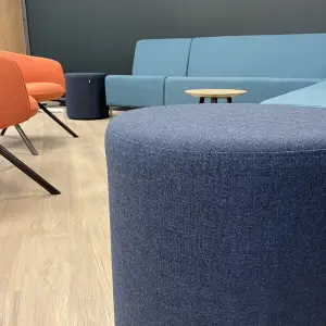 Amiosec break-out area with blue booth seating and an orange armchair