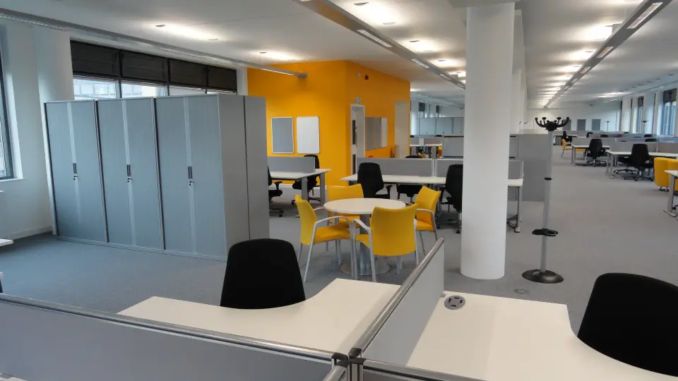 Office desks and breakout area with a yellow wall at Corsham CDP
