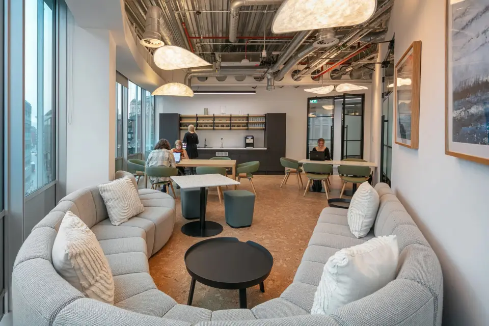 Office breakout area with a curved sofa and caf&eacute; seating
