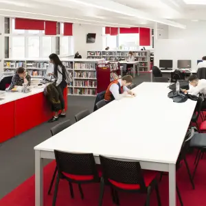 Pate&rsquo;s Grammar School library with a red issue desk and study tables