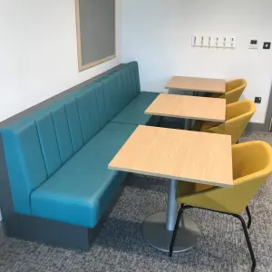Teal booth seating with tables at The Wilson Health Centre