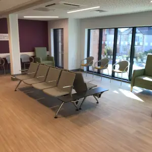 Waiting area with beam seating and armchairs at The Wilson Health Centre