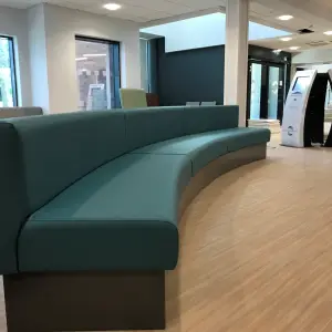 Curved teal bench seating in a waiting area at The Wilson Health Centre
