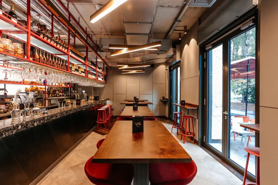 VQ Aldgate restaurant with long timber tables and red stools